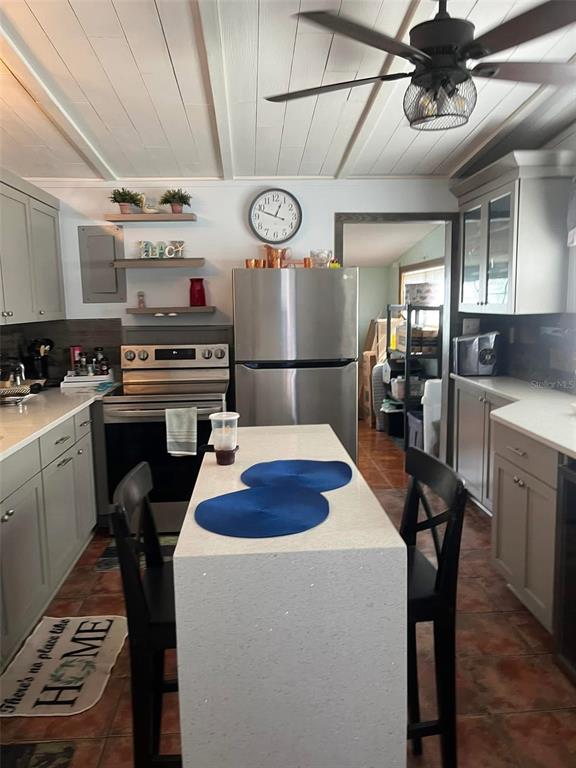 A kitchen features a central island, stainless steel appliances, grey cabinetry, and a ceiling fan — 1529 W RIVER LANE, TAMPA, FL
