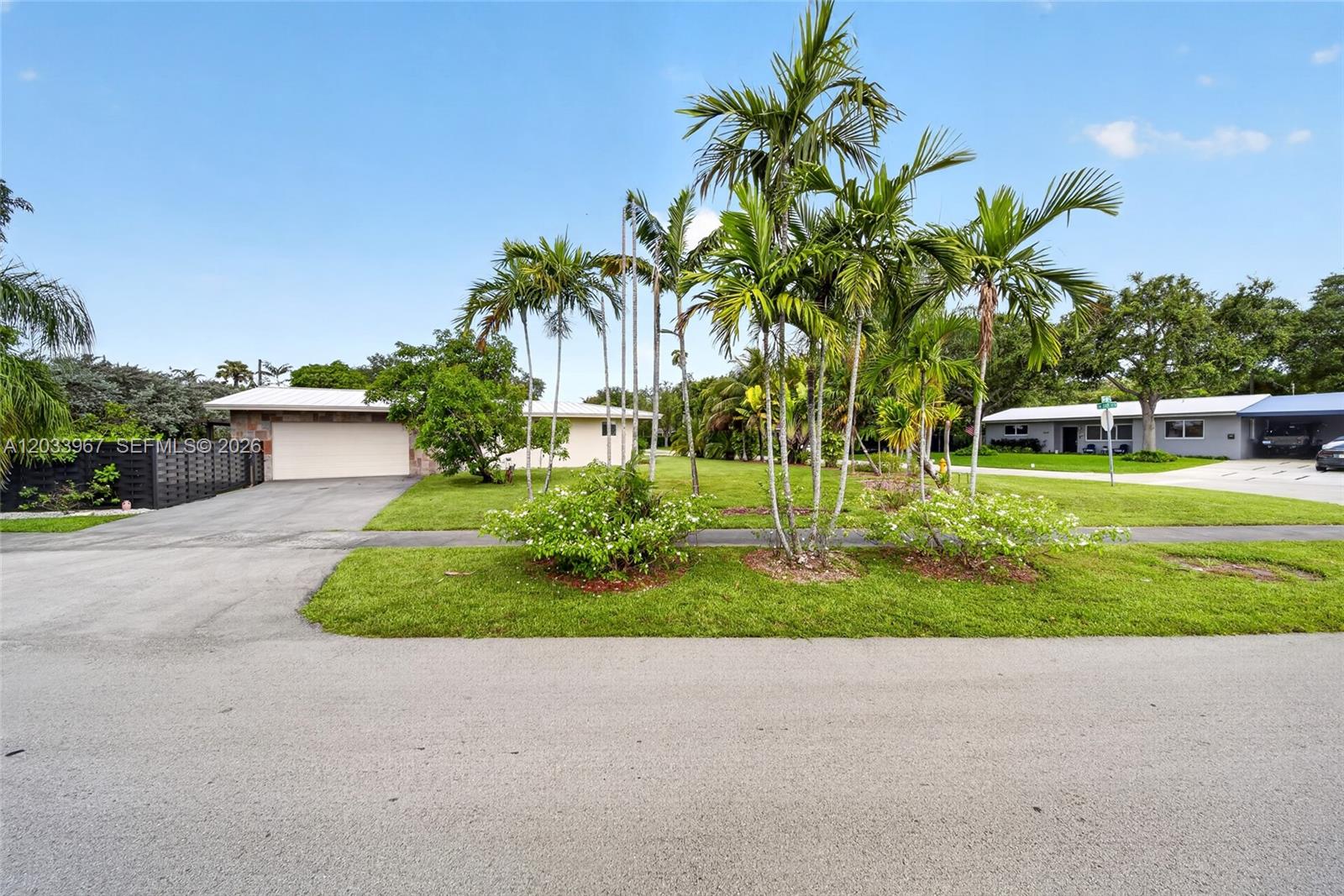 A single-story house with a garage and palm trees sits behind a grassy front yard — 8250 SW 118th Ter, Miami FL 33156, MIAMI, FL