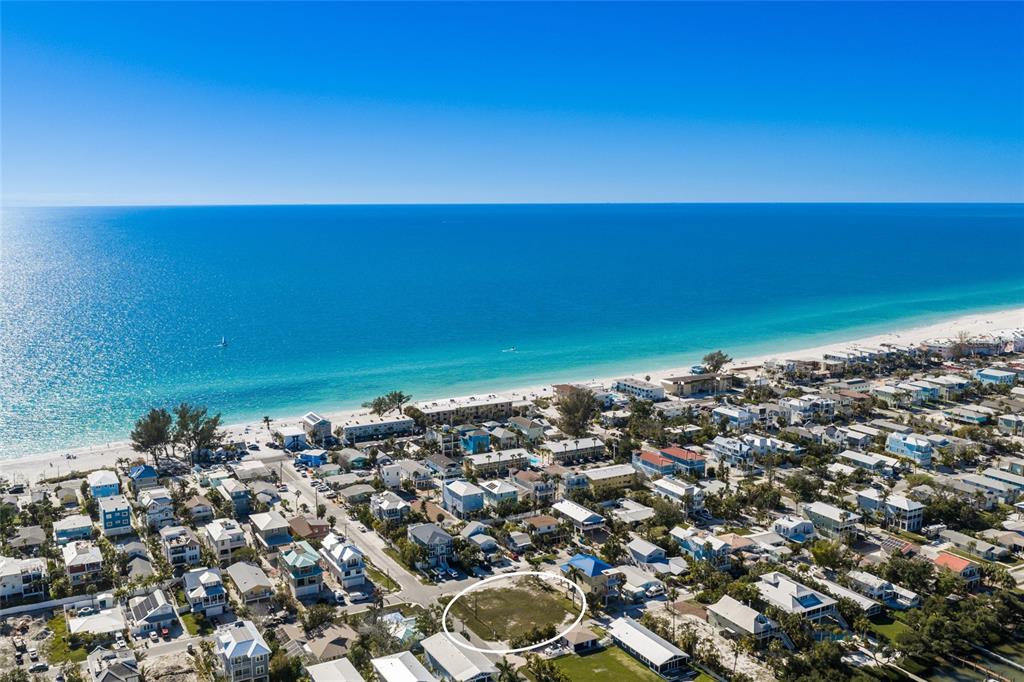 An aerial view shows a vacant lot circled in a coastal neighborhood near the beach — 300 23RD STREET N, BRADENTON BEACH, FL