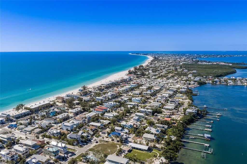 An aerial view shows a coastal neighborhood situated between a sandy beach and a bay — 300 23RD STREET N, BRADENTON BEACH, FL