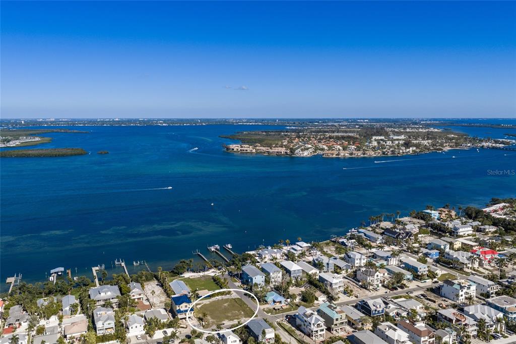 An aerial view shows a vacant, fenced-in residential lot near a waterfront neighborhood — 300 23RD STREET N, BRADENTON BEACH, FL