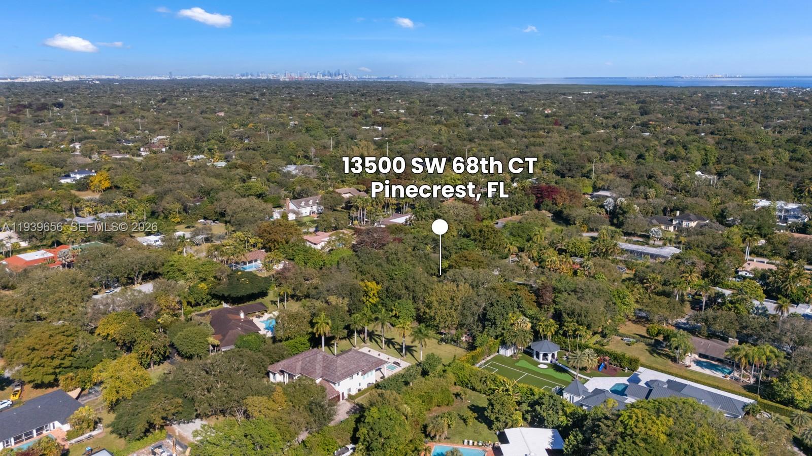 An aerial view shows a heavily wooded residential area with several large houses and pools — 13500 SW 68th Ct, Pinecrest FL 33156, PINECREST, FL