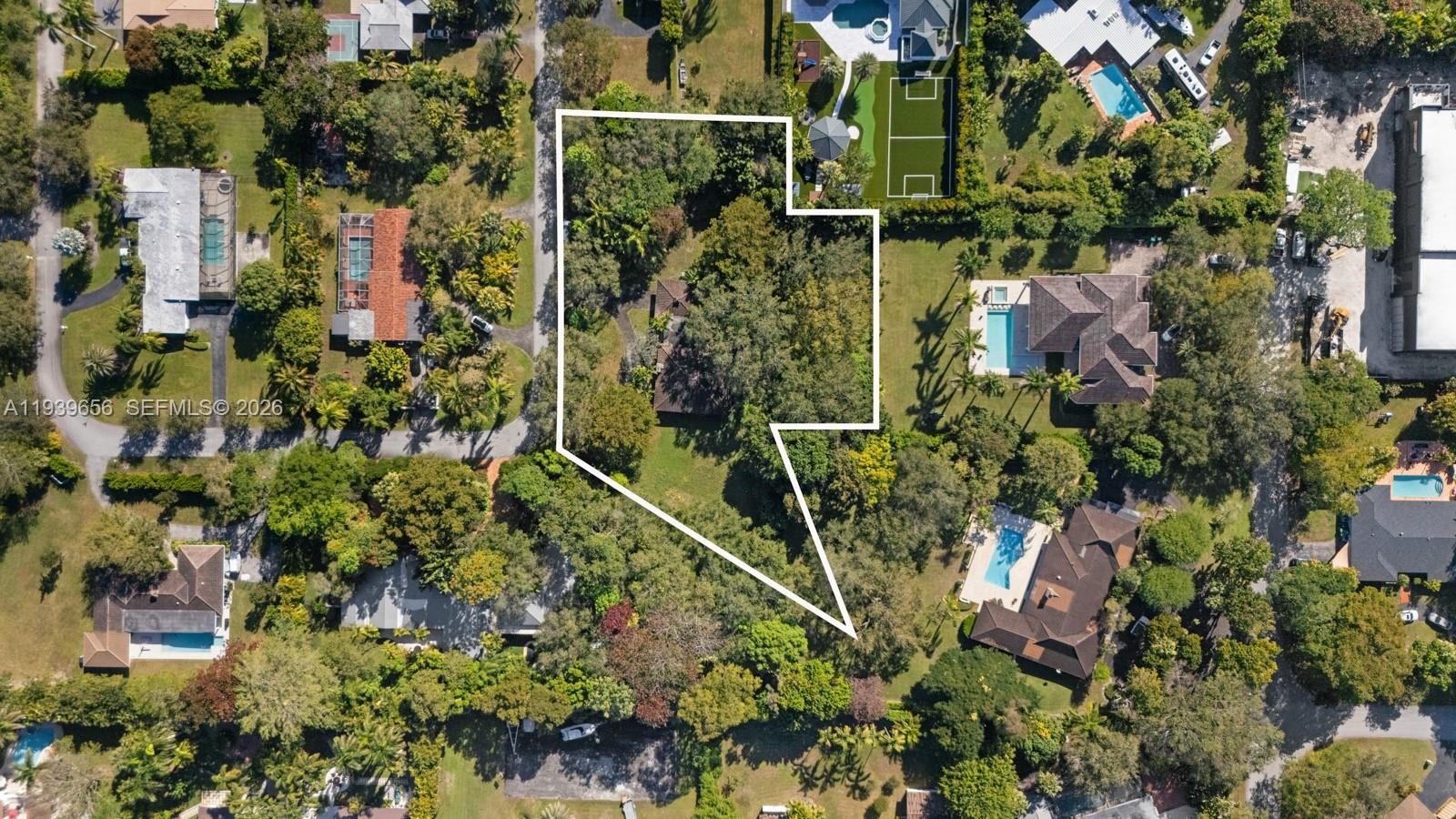 This aerial view shows a residential property lot outlined in white amidst surrounding homes — 13500 SW 68th Ct, Pinecrest FL 33156, PINECREST, FL