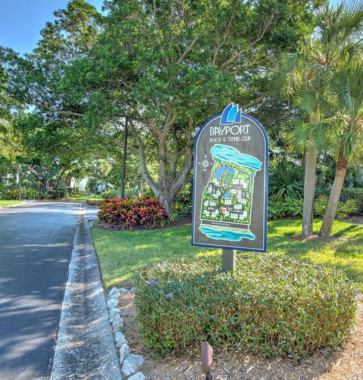A map sign for Bayport Beach & Tennis Club stands near a road and trees — 830 BAYPORT WAY UNIT 830, LONGBOAT KEY, FL