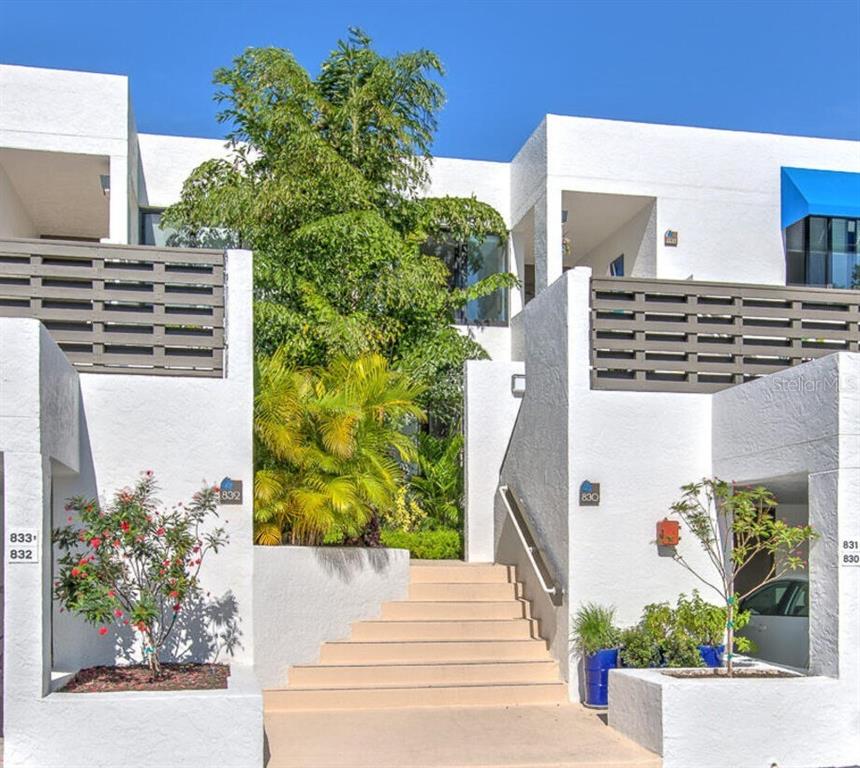 A set of concrete stairs leads to the entrance of a white multi-unit residential building — 830 BAYPORT WAY UNIT 830, LONGBOAT KEY, FL