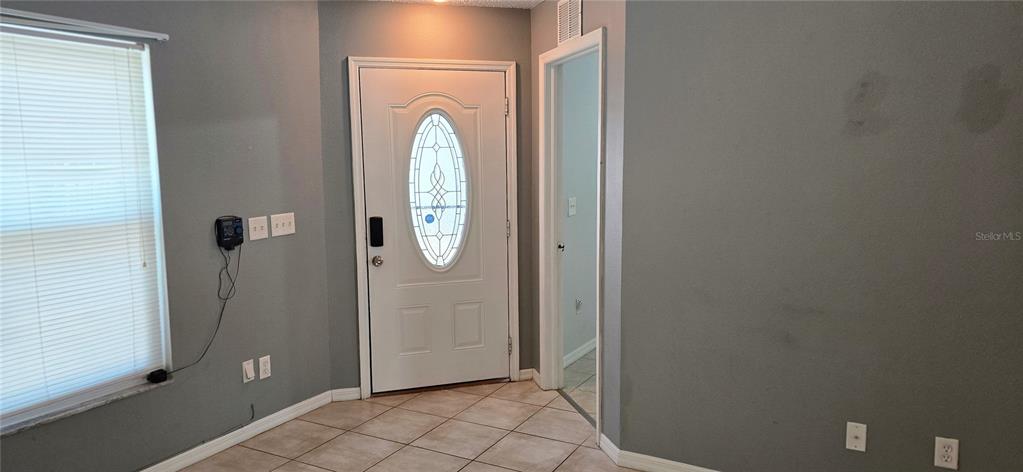 An entryway features a white front door with an oval window and tiled flooring — 3412 PALM BEACH DRIVE, VALRICO, FL