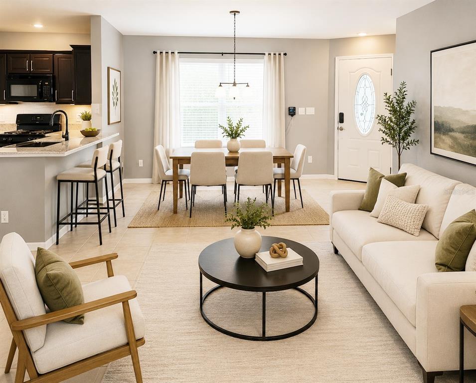 An open-concept living and dining area features a kitchen island, neutral furniture, and tile flooring — 3412 PALM BEACH DRIVE, VALRICO, FL