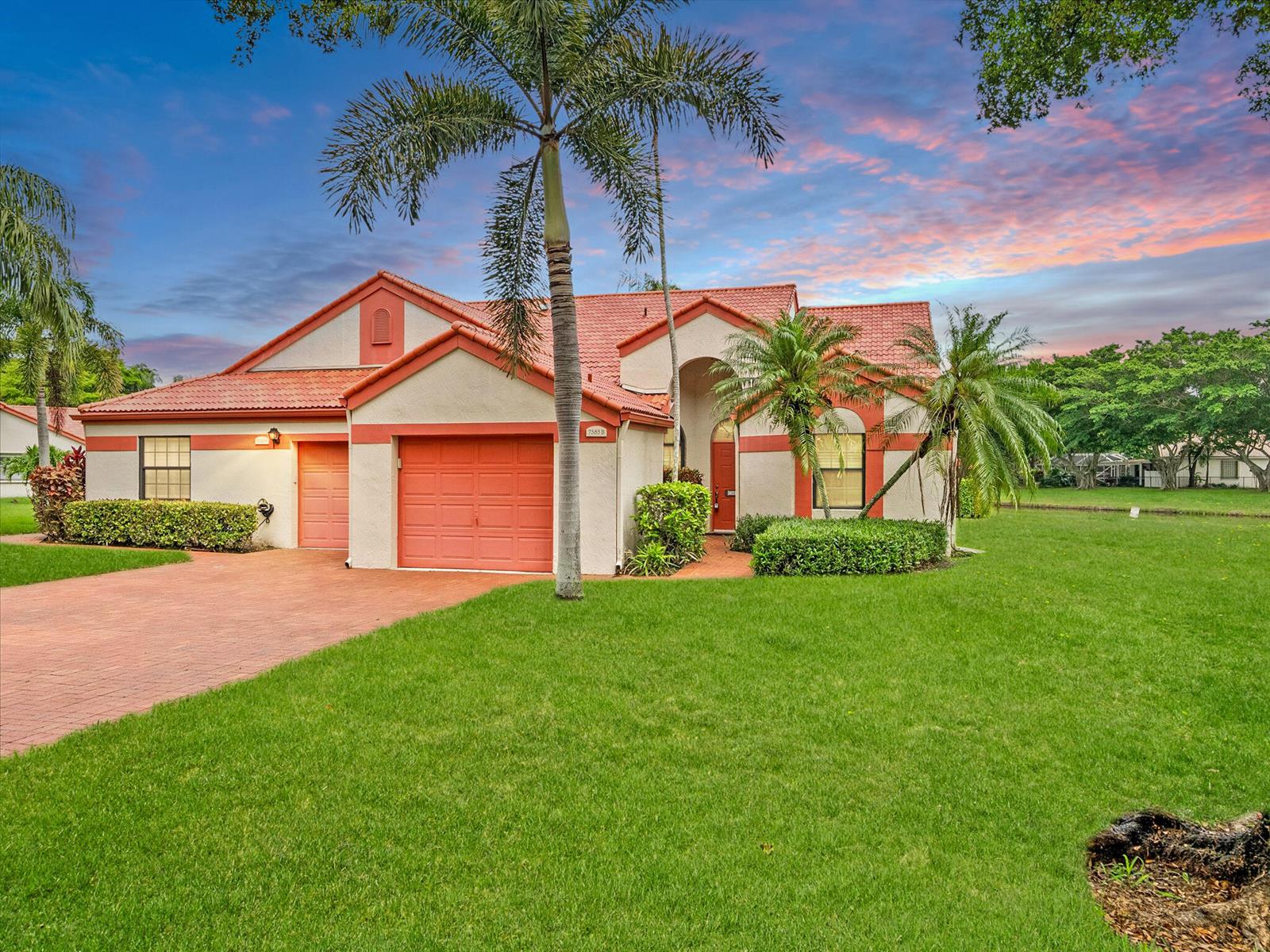 A single-story house with a red tile roof, orange garage doors, and a grassy lawn — 7585 Lexington Club Boulevard # B, Delray Beach FL 33446, DELRAY BEACH, FL