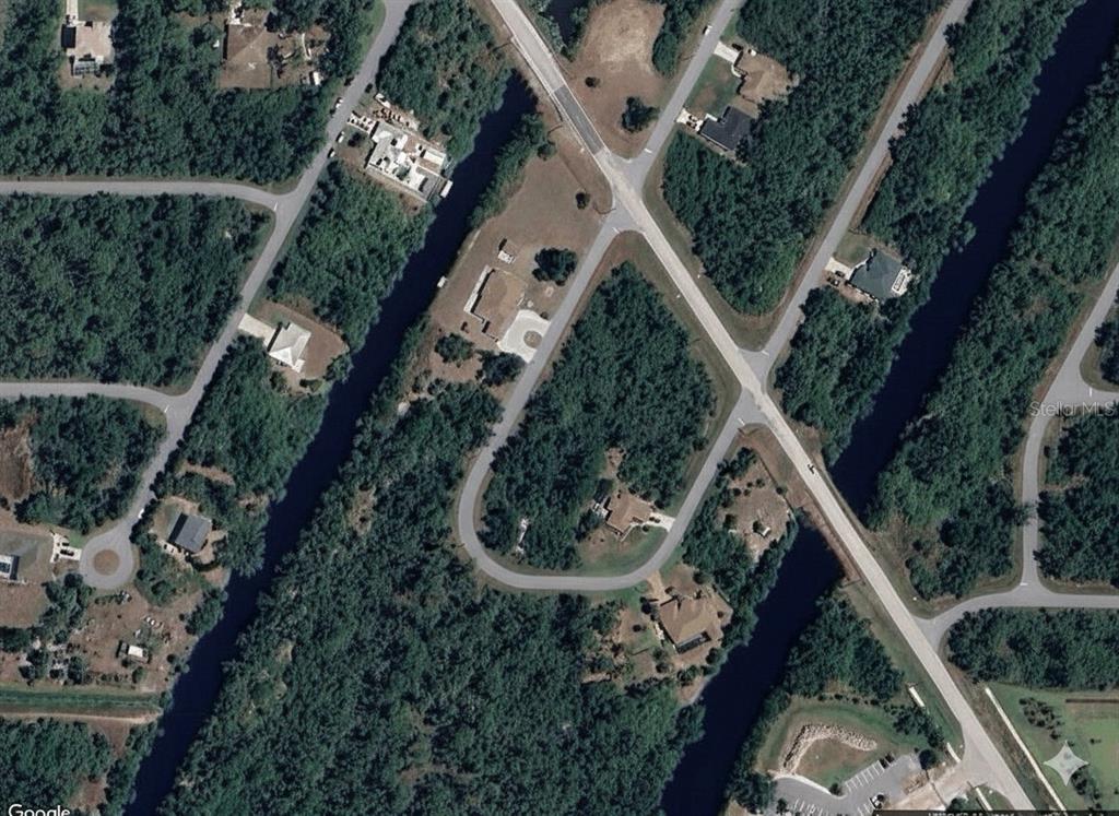This aerial view shows a residential neighborhood with houses, wooded lots, and winding roads — 2216 PRIVATE CIRCLE, PORT CHARLOTTE, FL