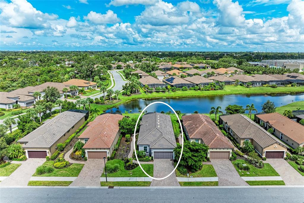 An aerial view shows a residential street with a single-story house circled in white — 8737 BELLUSSI DRIVE, SARASOTA, FL