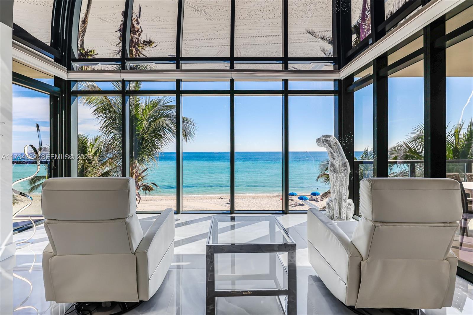 An aerial view of a sandy beach with rows of blue umbrellas and turquoise water — 2205 S Surf Rd # 4A, Hollywood FL 33019, HOLLYWOOD, FL