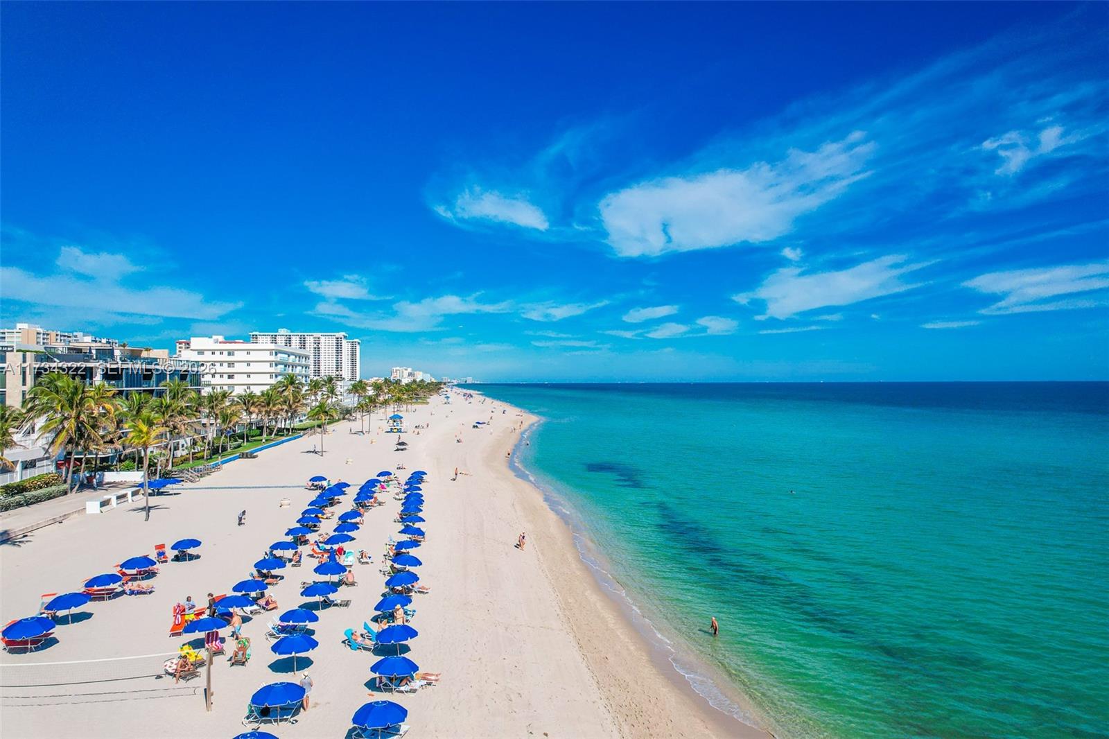 A modern white kitchen with a large marble island overlooks the ocean through floor-to-ceiling windows — 2205 S Surf Rd # 4A, Hollywood FL 33019, HOLLYWOOD, FL