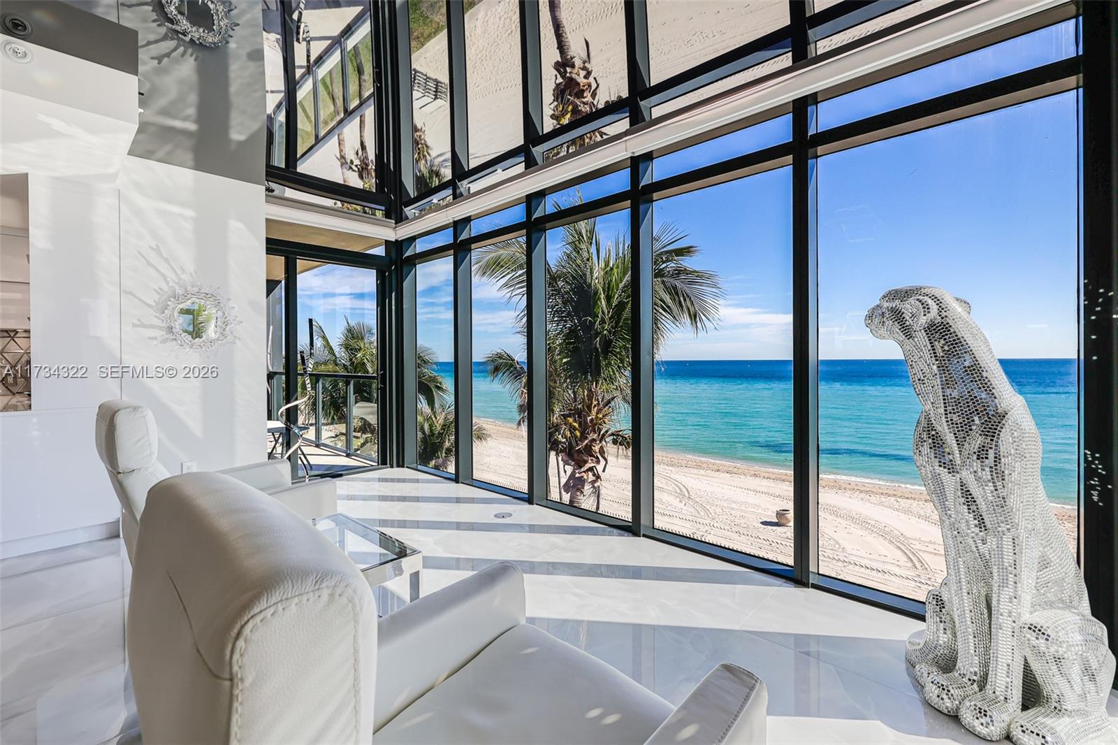 A hallway with glossy tile floors features a large triptych artwork illuminated by wall lighting — 2205 S Surf Rd # 4A, Hollywood FL 33019, HOLLYWOOD, FL