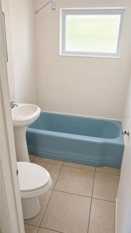 A room with tan tile flooring, a wood-paneled wall, and a stone-accented pillar — 6631 ROSATI LANE S, ST PETERSBURG, FL