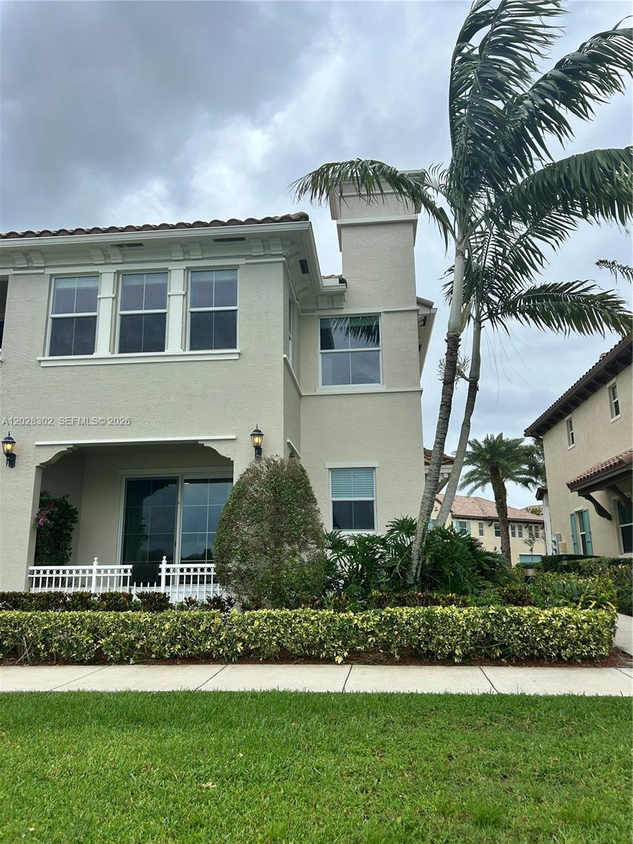 A concrete walkway leads between two residential buildings toward a lake under a blue sky — 3057 Tortola Way, Hollywood FL 33024, HOLLYWOOD, FL
