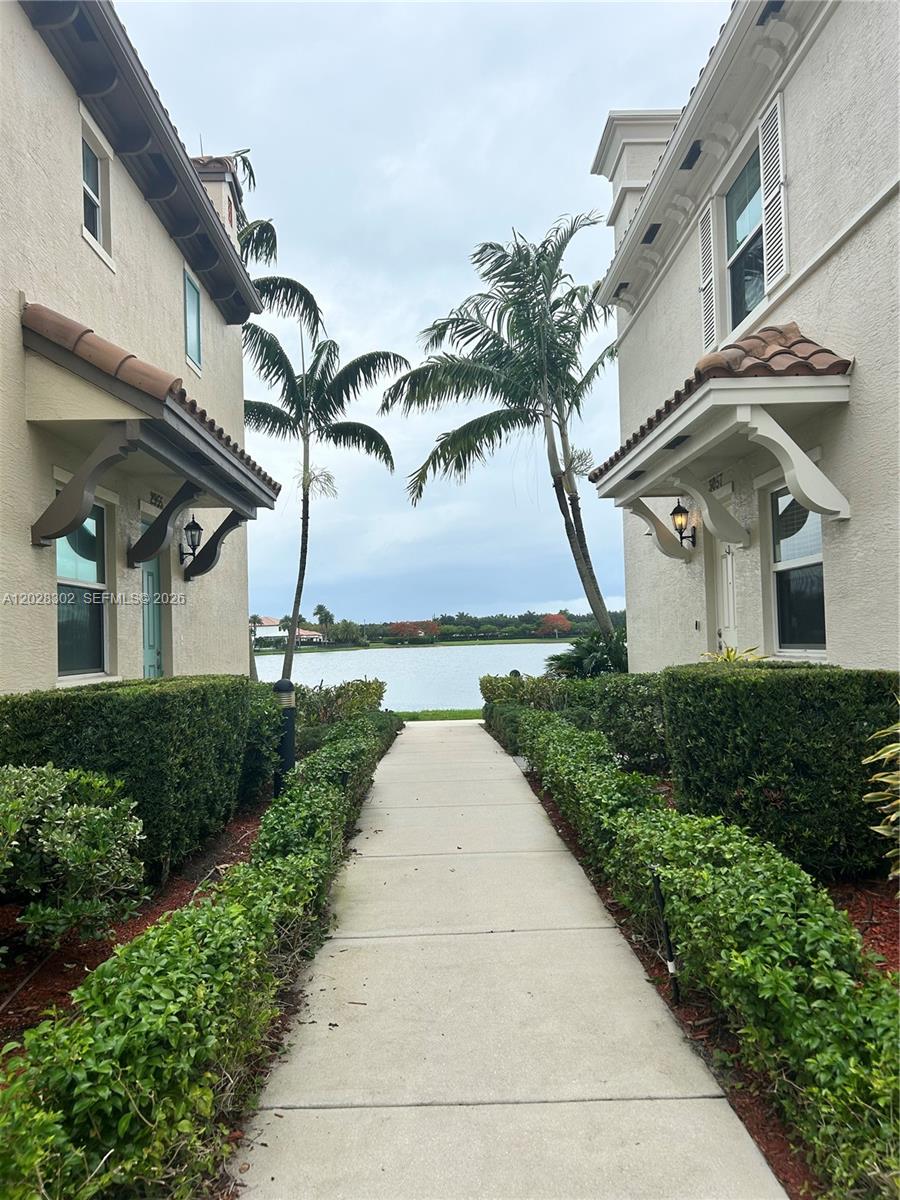A two-story residential building features a ground-floor patio with a white railing and landscaping — 3057 Tortola Way, Hollywood FL 33024, HOLLYWOOD, FL