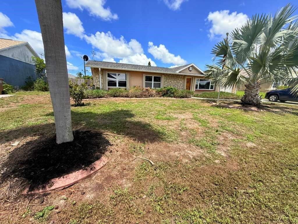 A single-story house with a stone facade and a palm tree in the front yard — 4418 SW 1ST AVENUE, CAPE CORAL, FL