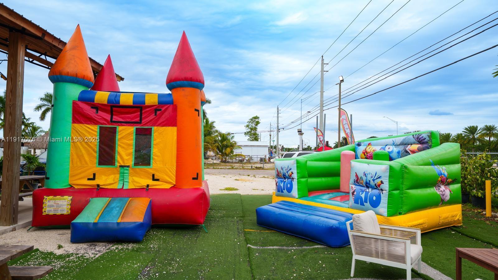 Two colorful inflatable bounce houses sit on an outdoor artificial turf area — 16860 SW 177TH AVE, Miami FL 33187, MIAMI, FL