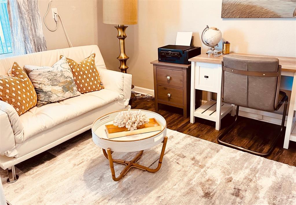 A living room features a white sofa, a round coffee table, and a desk area — 151 N ORLANDO AVENUE UNIT 203, WINTER PARK, FL