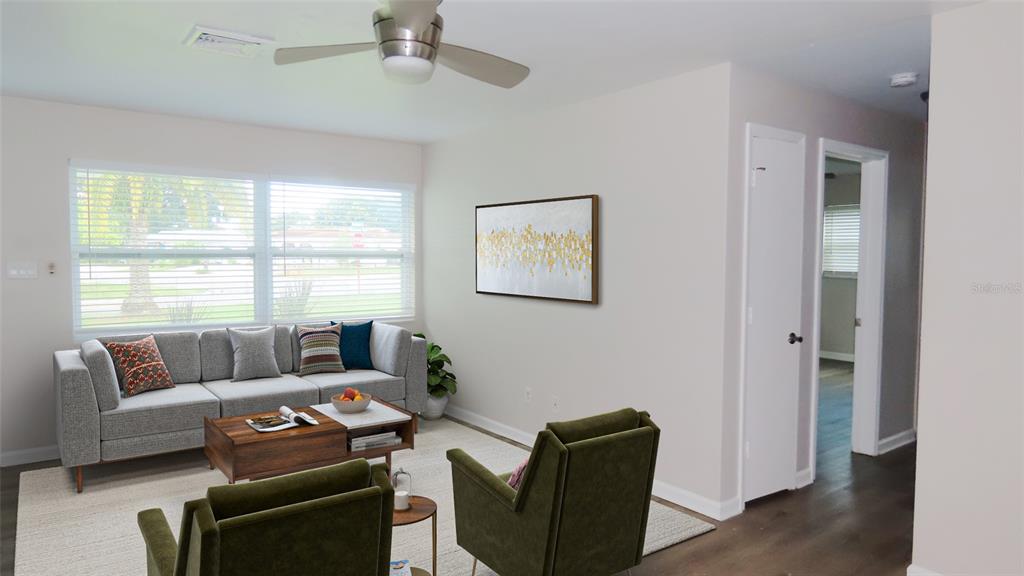A living room features a gray sofa, two green armchairs, and a wood coffee table — 2459 RUTLAND LANE, CLEARWATER, FL