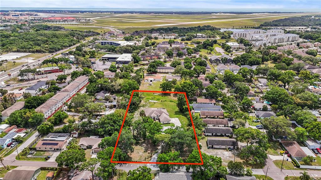 An aerial view shows a single-family home on a large, tree-filled lot outlined in red — 3902 W ELROD AVENUE, TAMPA, FL