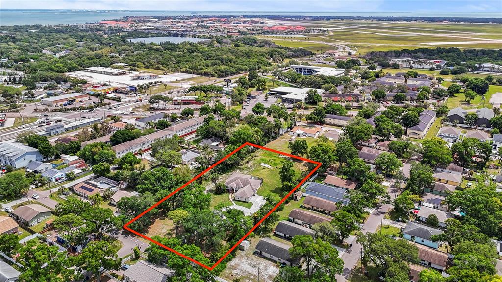 An aerial view shows a single-story house situated on a large, tree-filled residential lot — 3902 W ELROD AVENUE, TAMPA, FL