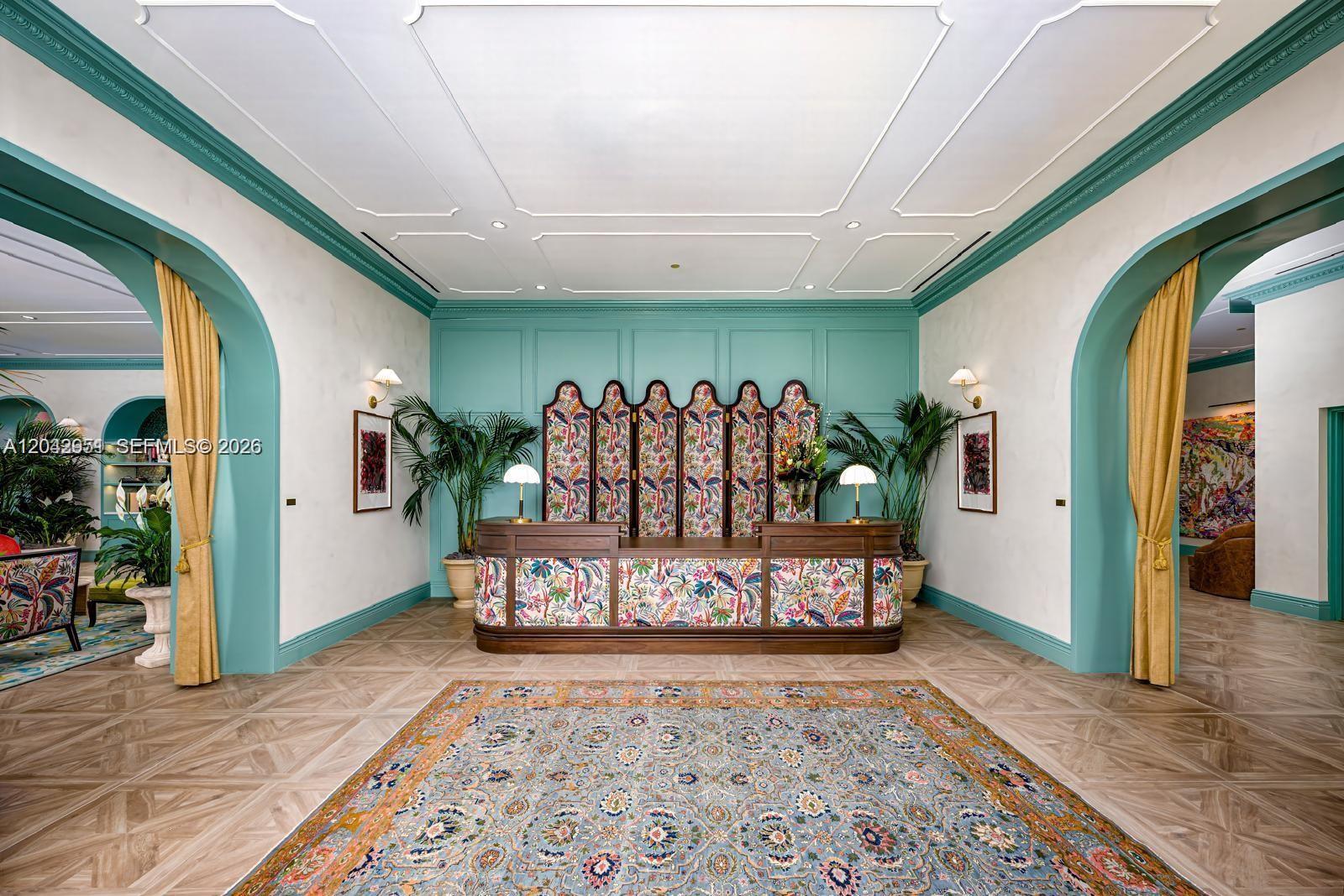 A reception area features a patterned desk, teal wall paneling, arched entryways, and a large rug — 2700 NW 2nd Avenue # 337, Miami FL 33127, MIAMI, FL