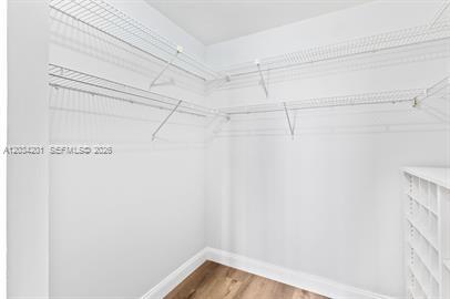 A walk-in closet features white wire shelving, white walls, and light wood-look flooring — 2500 Parkview Dr # 1216, Hallandale Beach FL 33009, HALLANDALE BEACH, FL