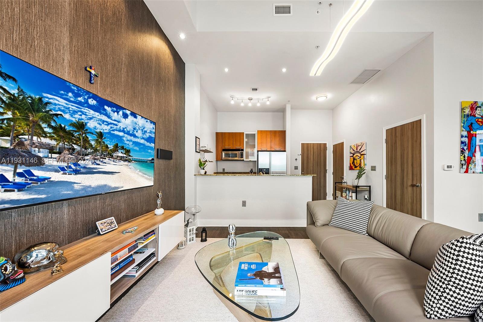 A living room features a large wall-mounted television, a glass coffee table, and a sofa — 9066 SW 73rd Ct # 405, Miami FL 33156, MIAMI, FL