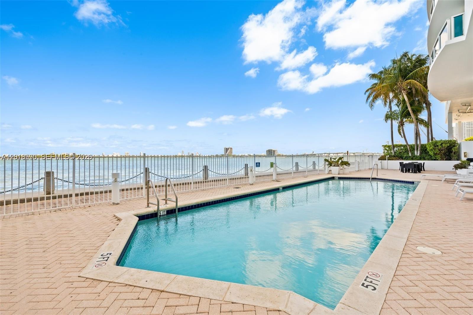 A swimming pool with a five-foot depth marker overlooks the ocean from a paved deck — 725 NE 22nd St, Miami FL 33137, MIAMI, FL