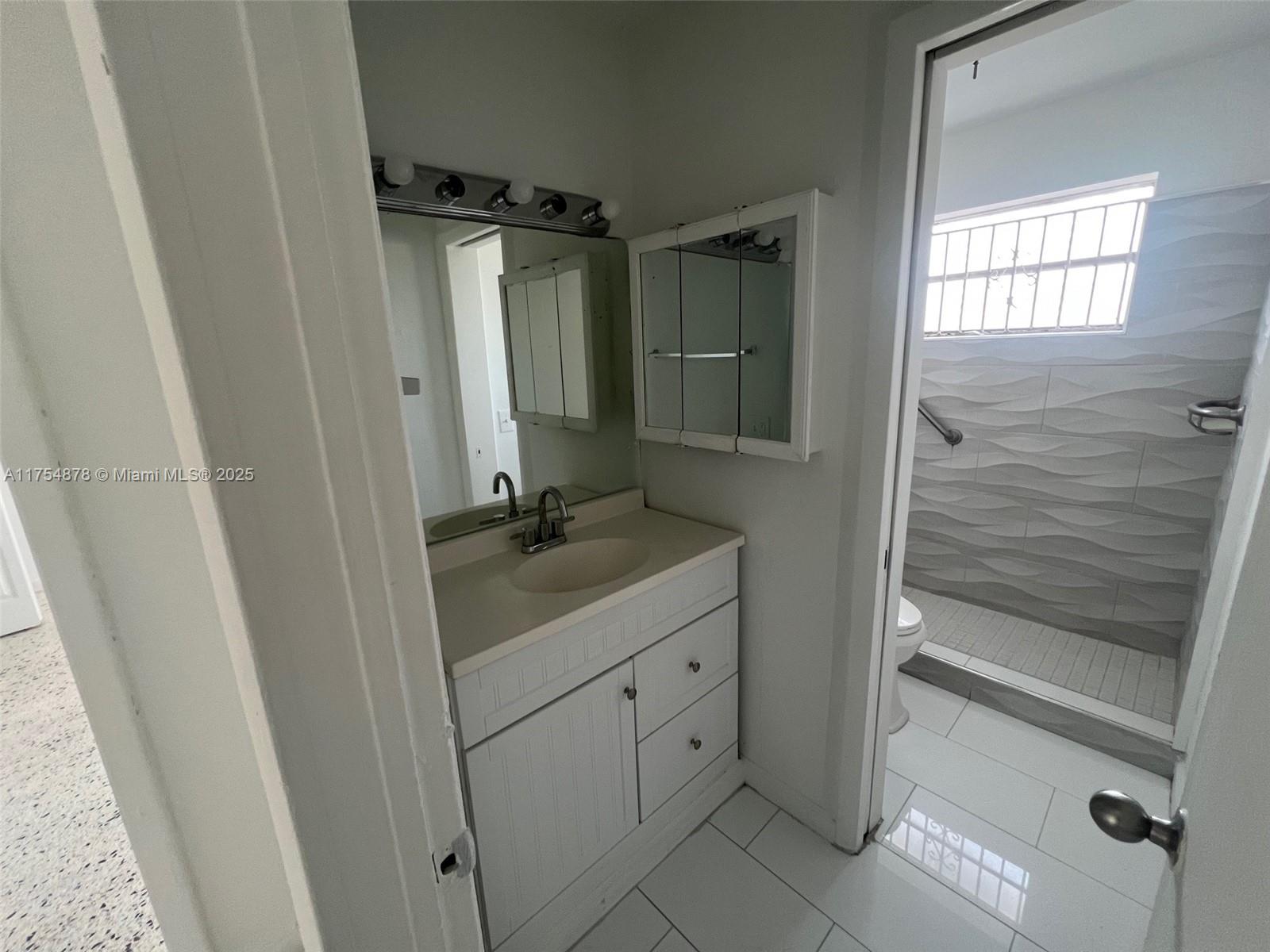 A bathroom features a white vanity, a medicine cabinet, and a walk-in shower — 887 W 29th St # 2, Hialeah FL 33012, HIALEAH, FL