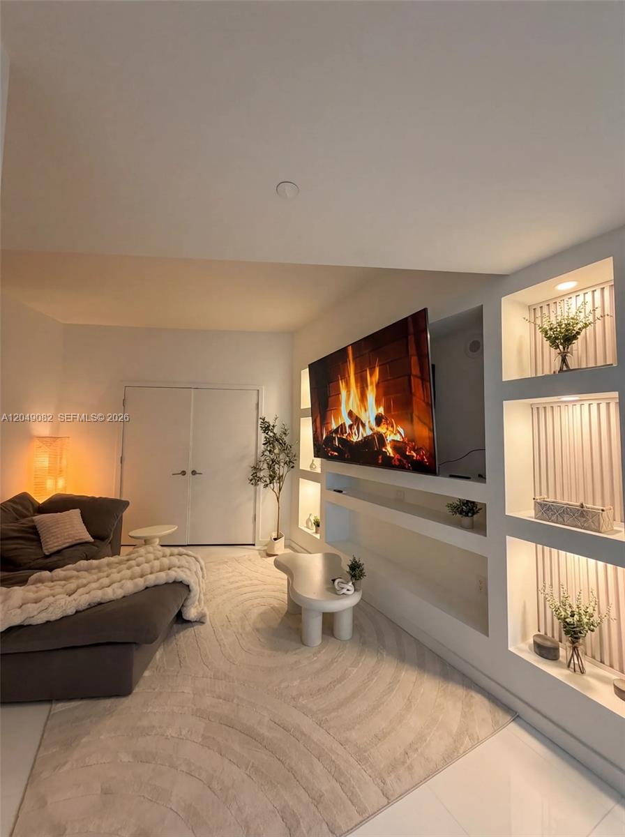 A living room features a wall-mounted television, recessed shelving, and a neutral-toned area rug — 851 NE 1st Ave # 2301, Miami FL 33132, MIAMI, FL