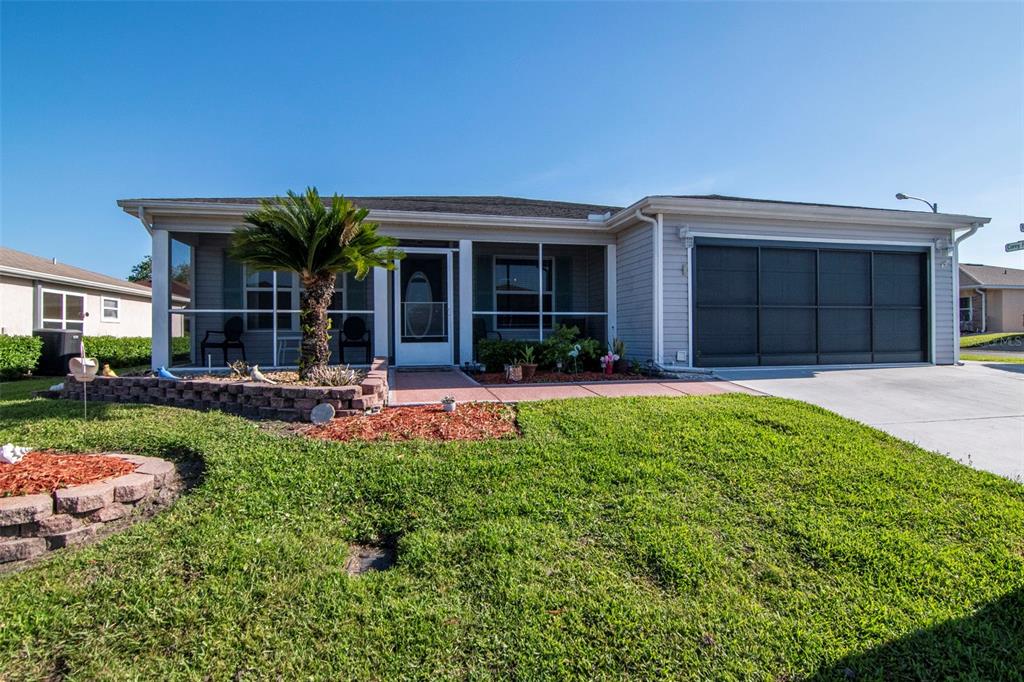A single-story house with a screened front porch, a palm tree, and a two-car garage — 29236 KAPALUA WAY, SAN ANTONIO, FL