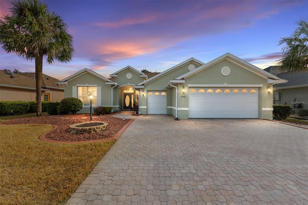A single-story house with a paved driveway, a three-car garage, and a landscaped front yard — 8785 SW 82ND COURT ROAD, OCALA, FL