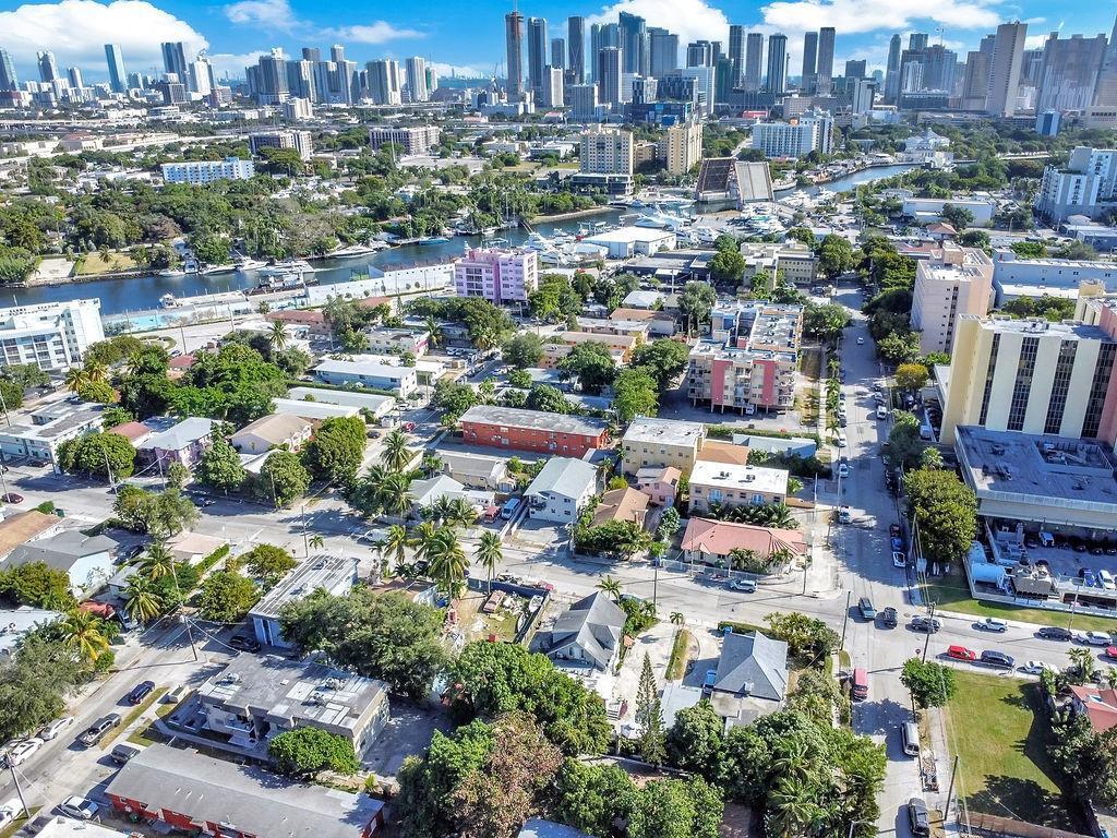 An aerial view of a neighborhood with low-rise buildings and a distant city skyline — 429 NW 10th Avenue, Miami FL 33128, MIAMI, FL