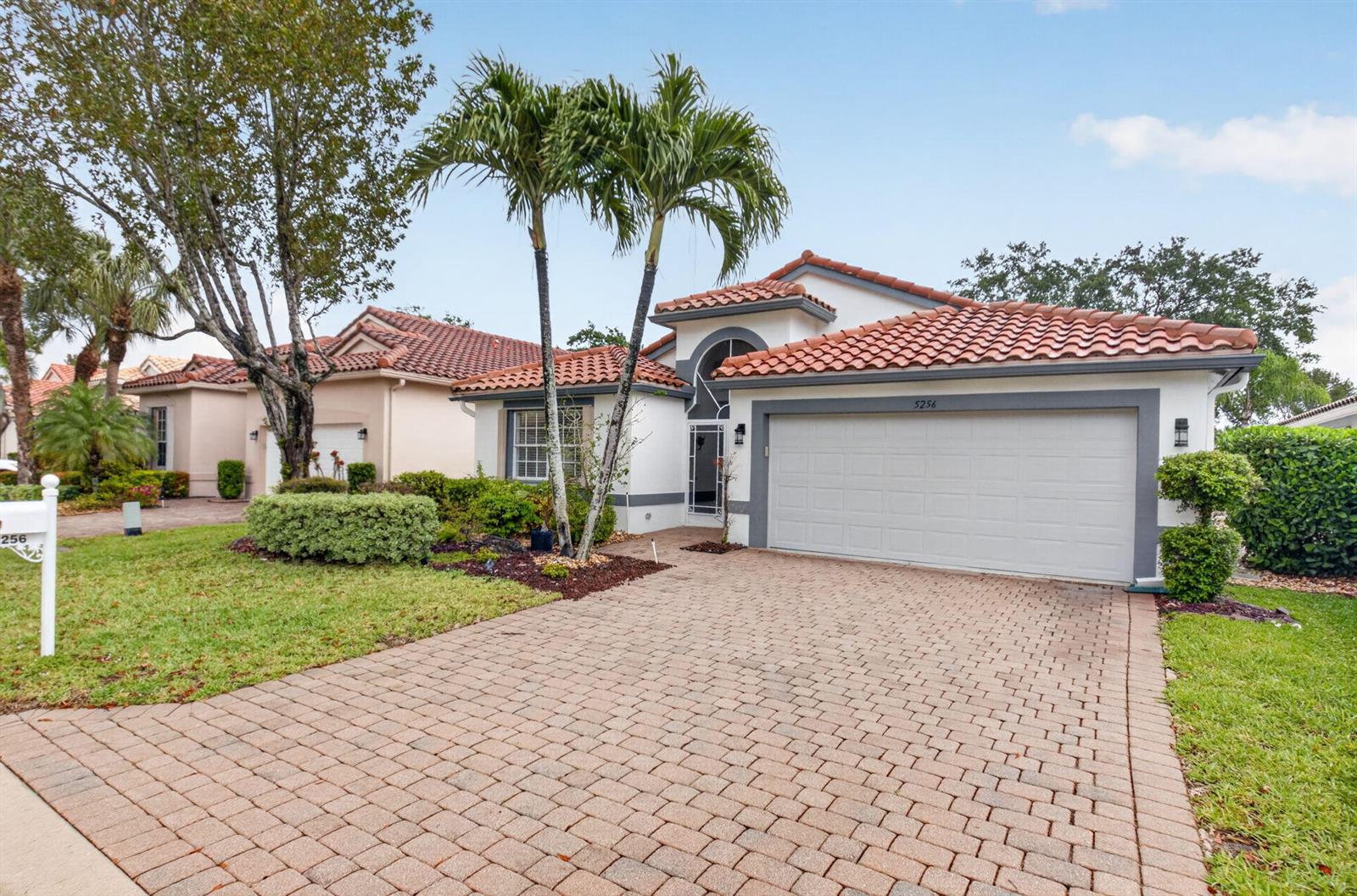 A one-story suburban house with a tiled roof, two-car garage, and a paved driveway — 5256 Glenville Drive, Boynton Beach FL 33437, BOYNTON BEACH, FL