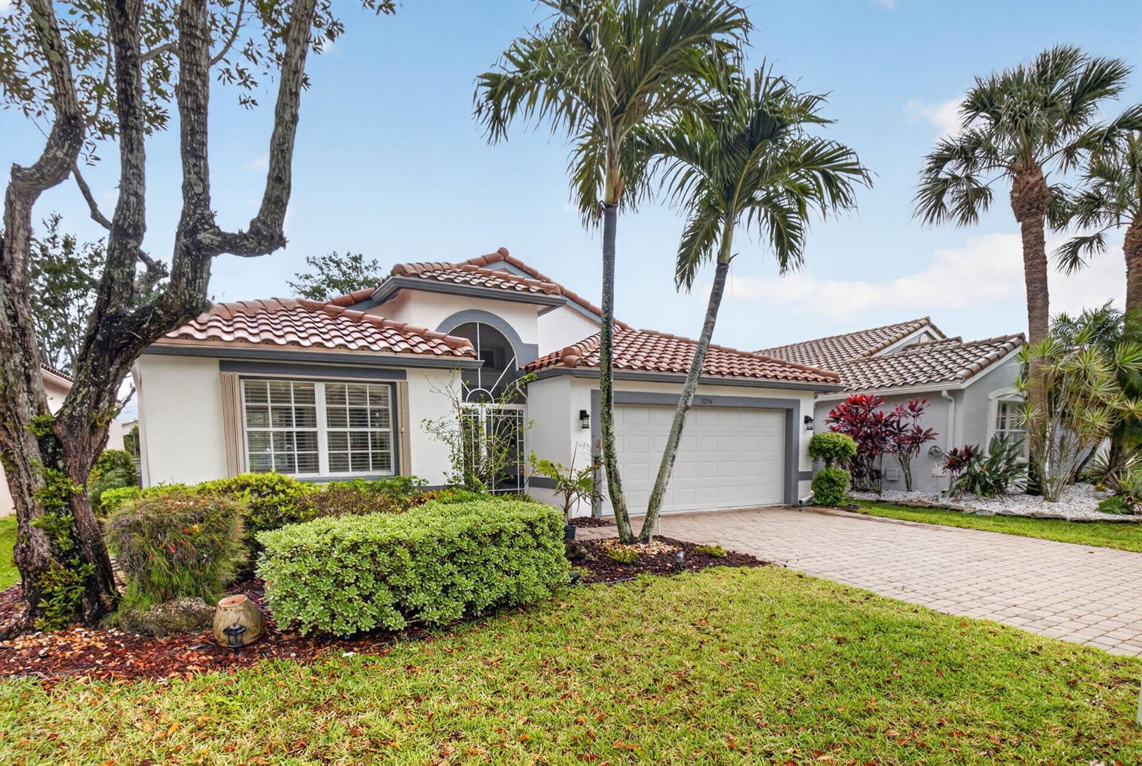 A single-story house with a white stucco exterior, tile roof, and a paved driveway — 5256 Glenville Drive, Boynton Beach FL 33437, BOYNTON BEACH, FL