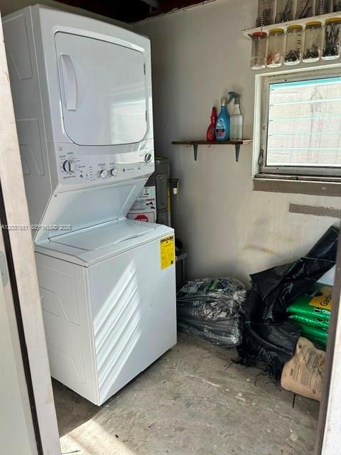 A stacked washer and dryer unit sits in a utility room with a small window — BOYNTON BEACH, FL