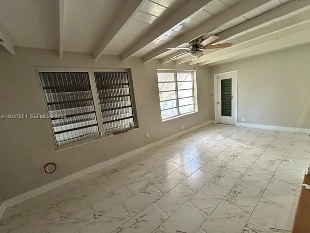 An interior room features white marble-look tile flooring, exposed ceiling beams, and a ceiling fan — BOYNTON BEACH, FL