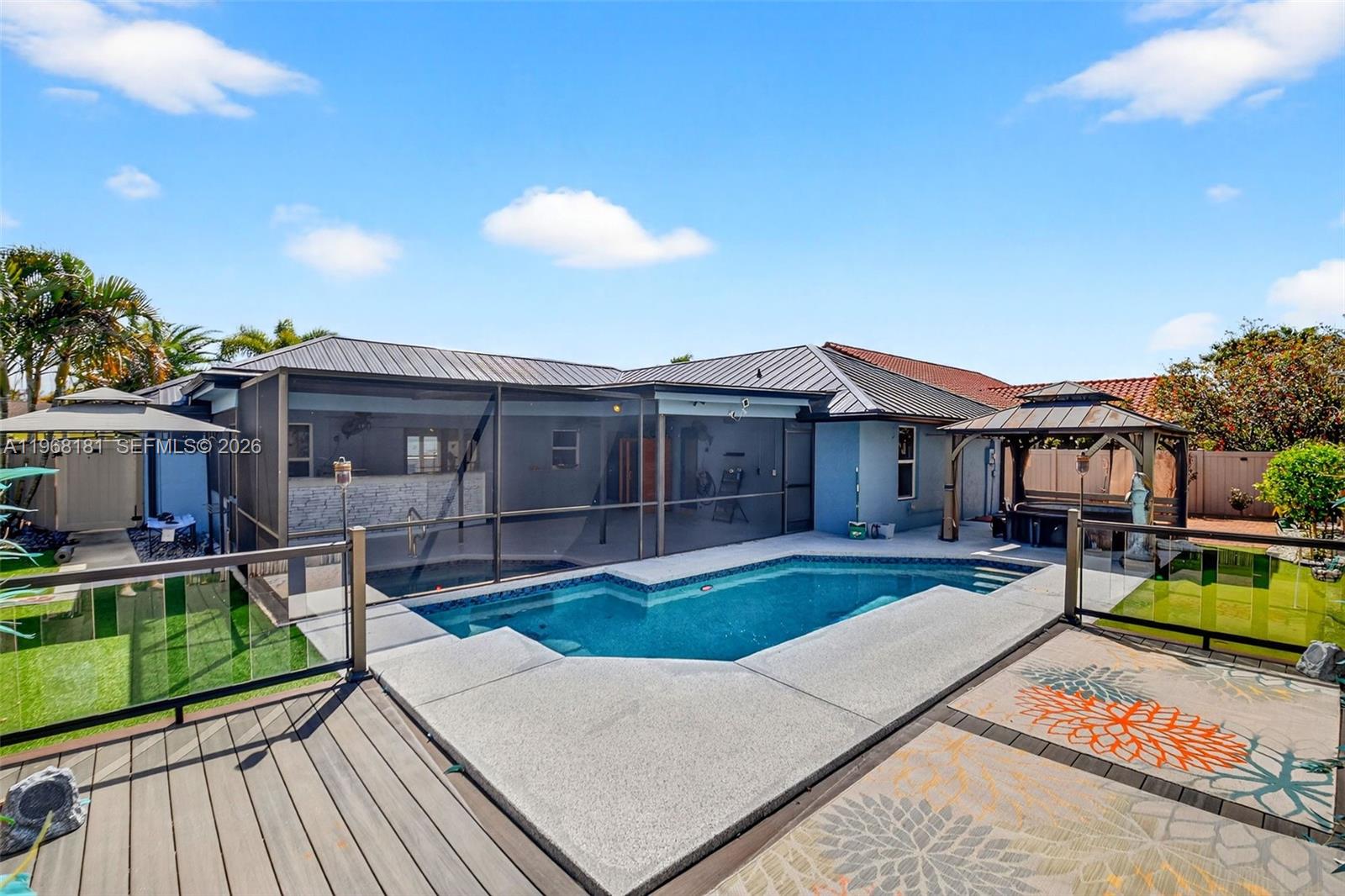 A backyard features a swimming pool, a screened-in patio, and a wooden deck — 13808 Geranium Pl, Wellington FL 33414, WELLINGTON, FL