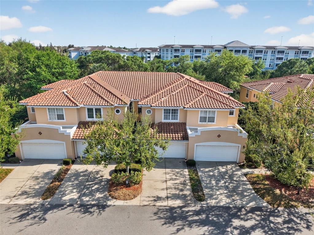 An aerial view of a two-story townhouse complex with a tiled roof and garages — 184 VALENCIA CIRCLE, ST PETERSBURG, FL