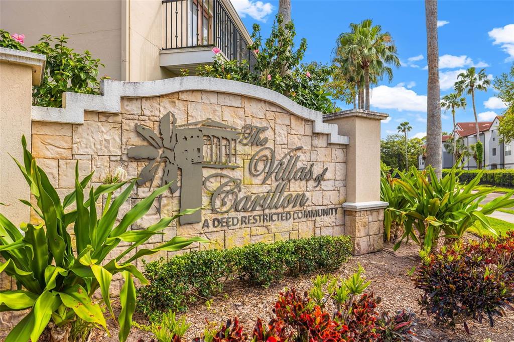 A stone monument sign for The Villas of Carillon stands in a landscaped garden area — 184 VALENCIA CIRCLE, ST PETERSBURG, FL