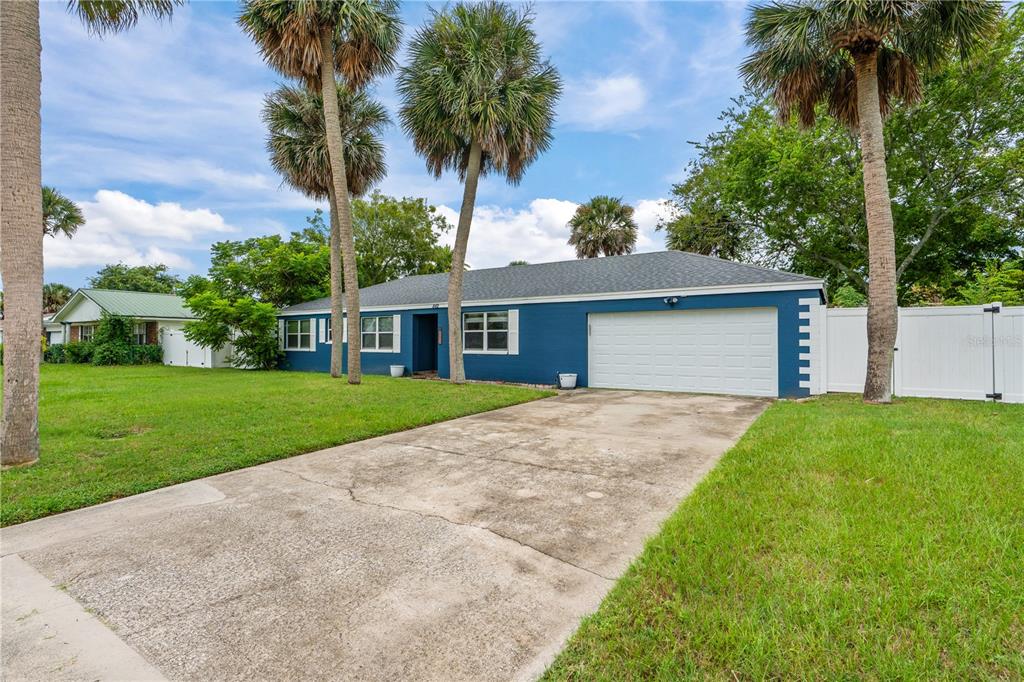 A blue single-story house with a white garage door and a concrete driveway — 882 W COQUINA DRIVE, DAYTONA BEACH, FL