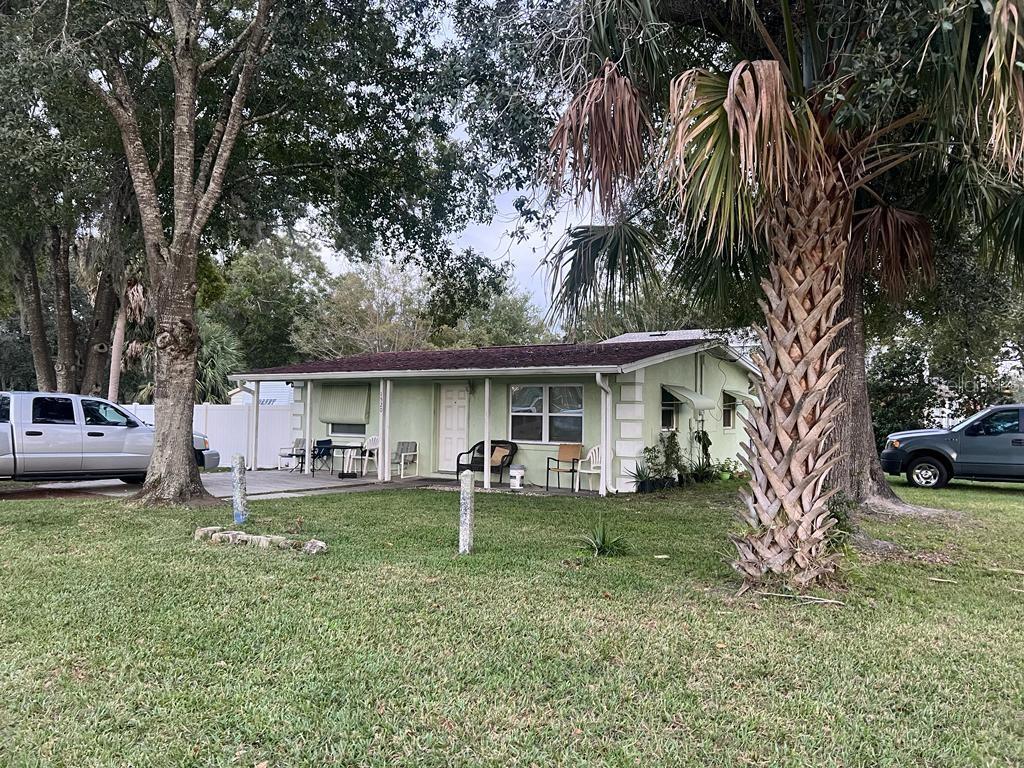 A single-story light green house with a covered front porch sits on a grassy lot — 1520 HILL STREET, KISSIMMEE, FL