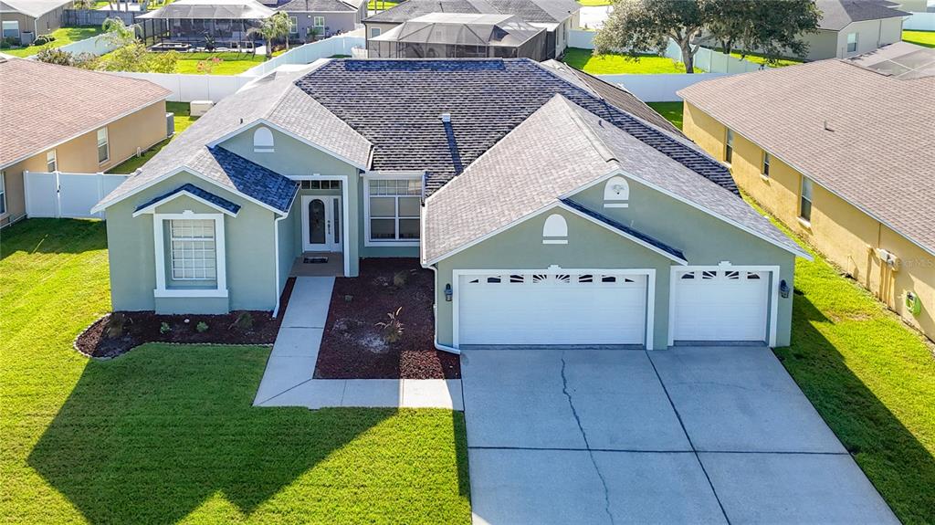 An aerial view of a single-story suburban house with a three-car garage and lawn — 24807 BLAZING TRAIL WAY, LAND O LAKES, FL