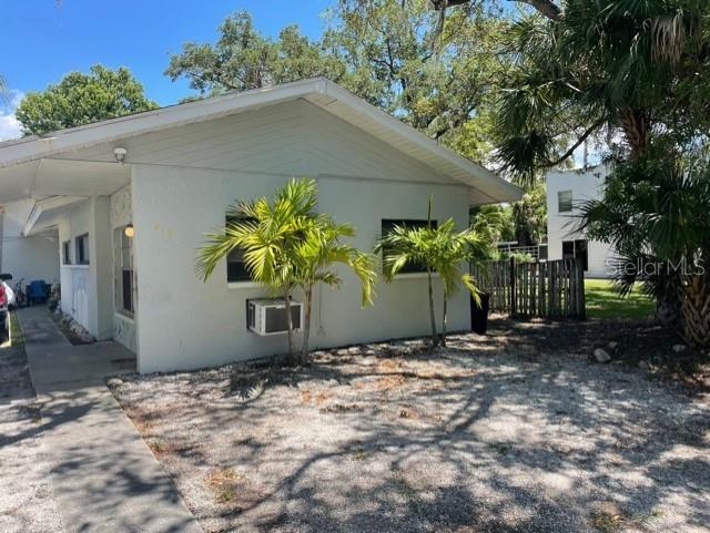 A light-colored, single-story house features a gravel yard, two palm trees, and a window unit — 419 PINEAPPLE STREET UNIT 3, TARPON SPRINGS, FL
