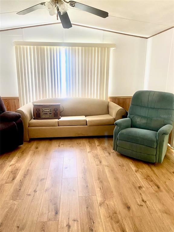 A living room features a beige sofa, a teal recliner, and wood-look flooring — 622 COTTAGE PARK LANE, LEESBURG, FL