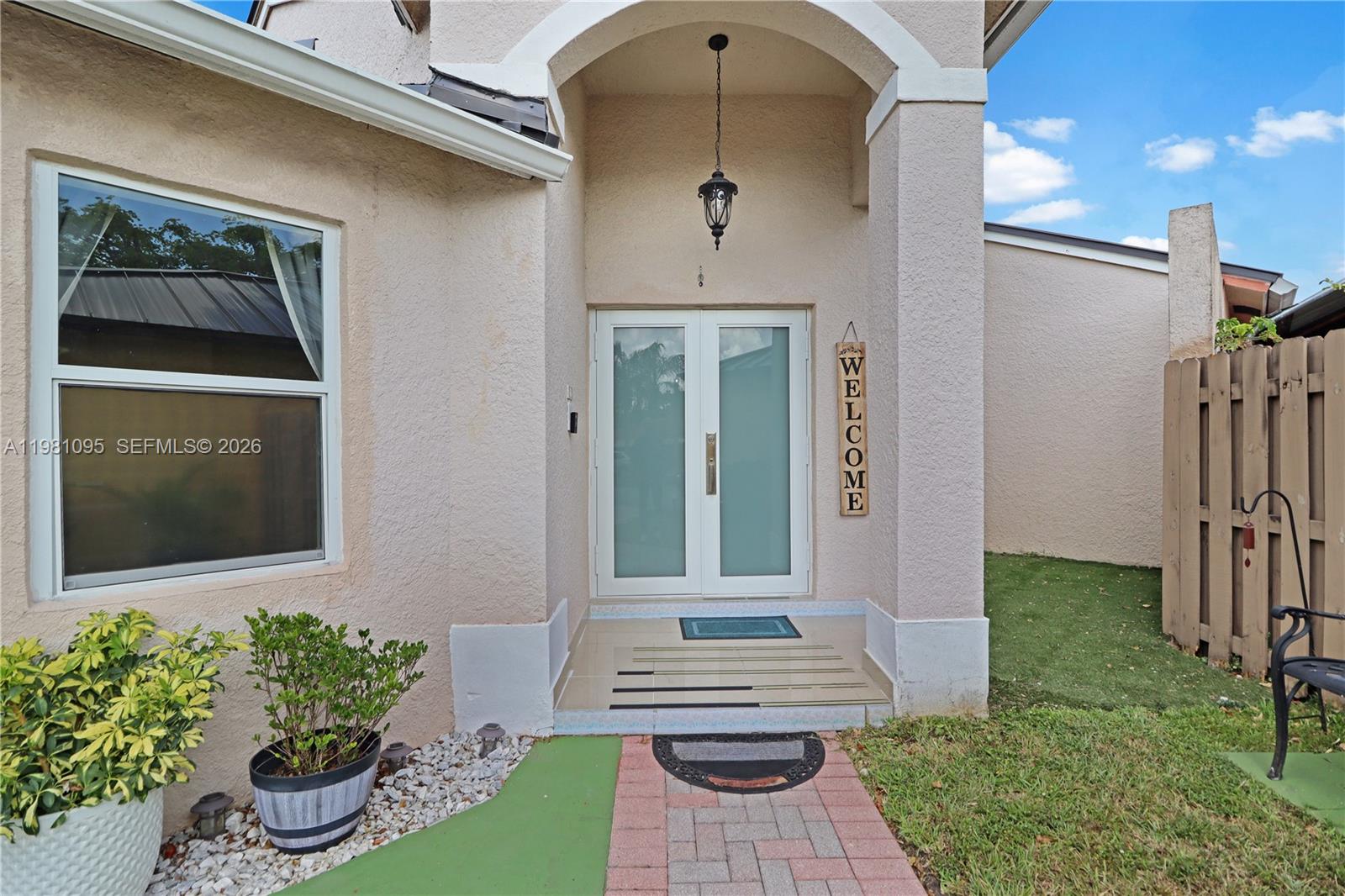 The exterior of a house features a double glass door entrance with a welcome sign — 8070 SW 157th Pl, Miami FL 33193, MIAMI, FL