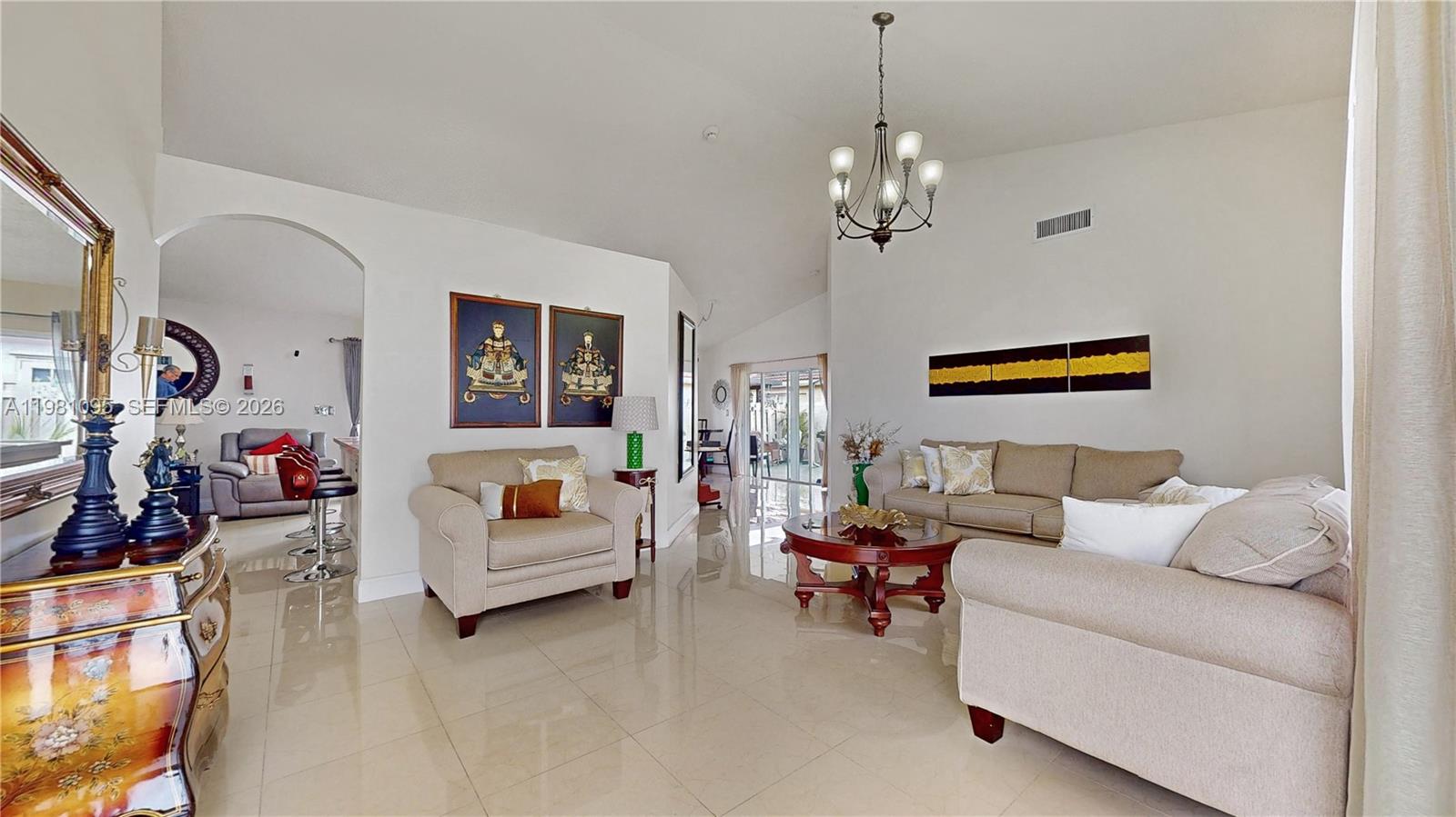 A living room features beige furniture, a round coffee table, and a chandelier on tile — 8070 SW 157th Pl, Miami FL 33193, MIAMI, FL