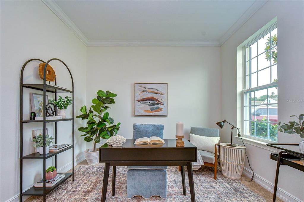 A home office features a dark desk, blue upholstered chair, bookshelf, and a large window — 4749 ROLLING GREEN DRIVE, WESLEY CHAPEL, FL